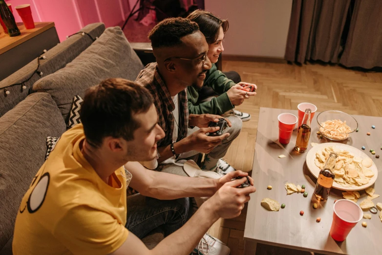 a group of people sitting around a table eating pizza, playing video games, lgbtq, fancy apartment, fall guys