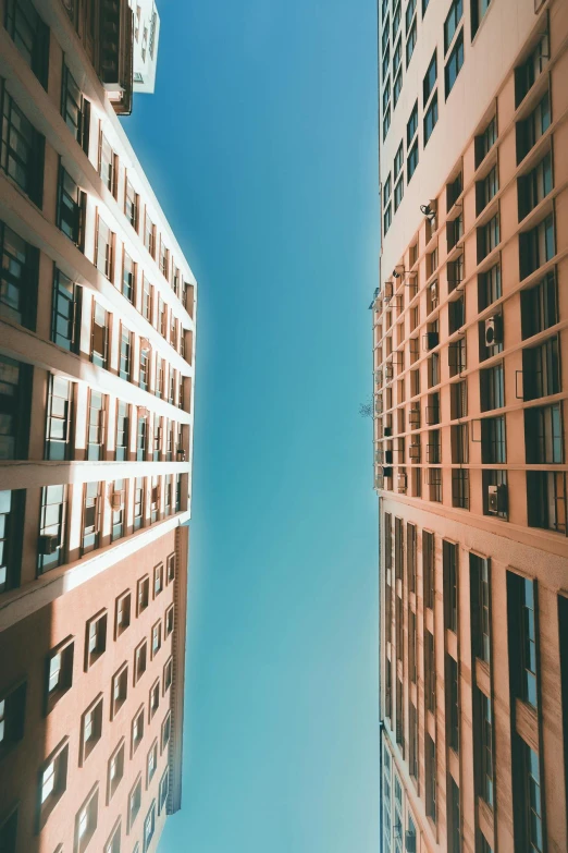 a couple of tall buildings next to each other, a picture, pexels contest winner, square lines, clear skies, flat, opening shot