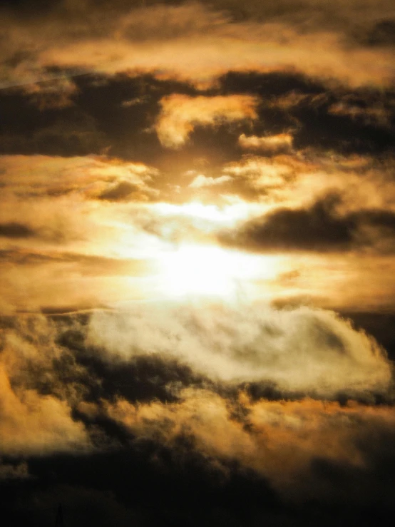 a plane flying through a cloudy sky at sunset, an album cover, by Jan Tengnagel, unsplash, romanticism, a yellow sun shining down, profile image, heavy clouds, golden hour closeup photo