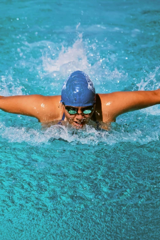 a close up of a person swimming in a pool, spreading her wings, wearing goggles, square, college