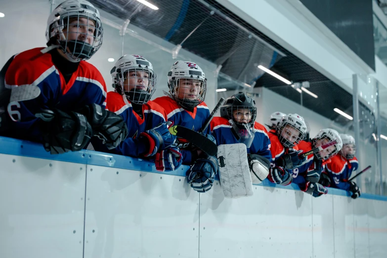 a group of young men sitting on top of a hockey rink, pexels contest winner, helmet view, thumbnail, children's, high quality photo