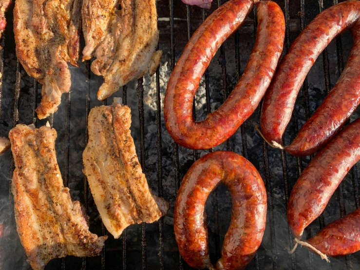 a bunch of sausages are cooking on a grill, by Joe Bowler, pexels contest winner, renaissance, patagonian, wide overhead shot, sunken, ribs