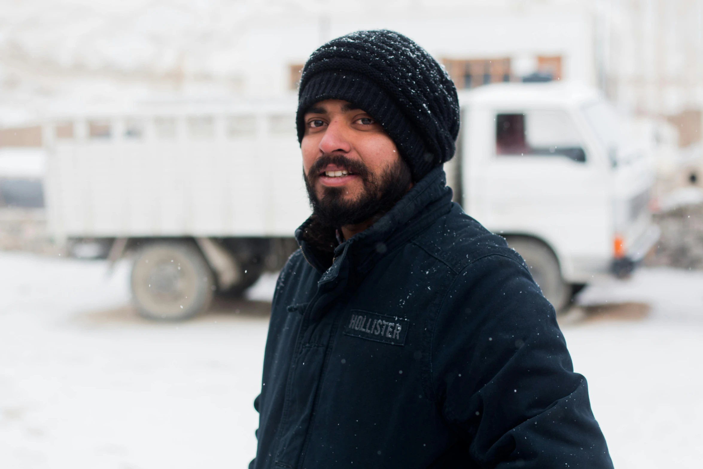 a man standing in the snow in front of a truck, a portrait, pexels contest winner, hurufiyya, avatar image, an afghan male type, profile image, high resolution photo