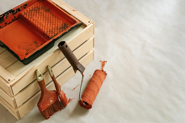 a couple of tools sitting on top of a wooden box, a silk screen, inspired by Howard Hodgkin, unsplash, arte povera, gray and orange colours, close-up product photo, brown, on a pale background