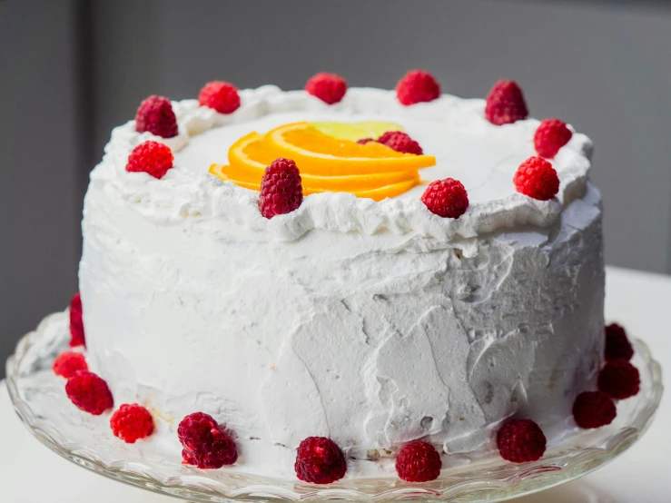 a cake with white frosting and raspberries on top, pexels, mango, promo image, voluminous, full product shot