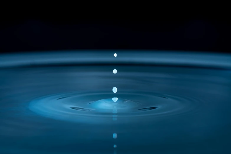 a drop of water falling into a pool of water, inspired by Lucio Fontana, unsplash, minimalism, bioluminescent orbs, realistic physical rendering, photograph taken in 2 0 2 0, low - angle shot