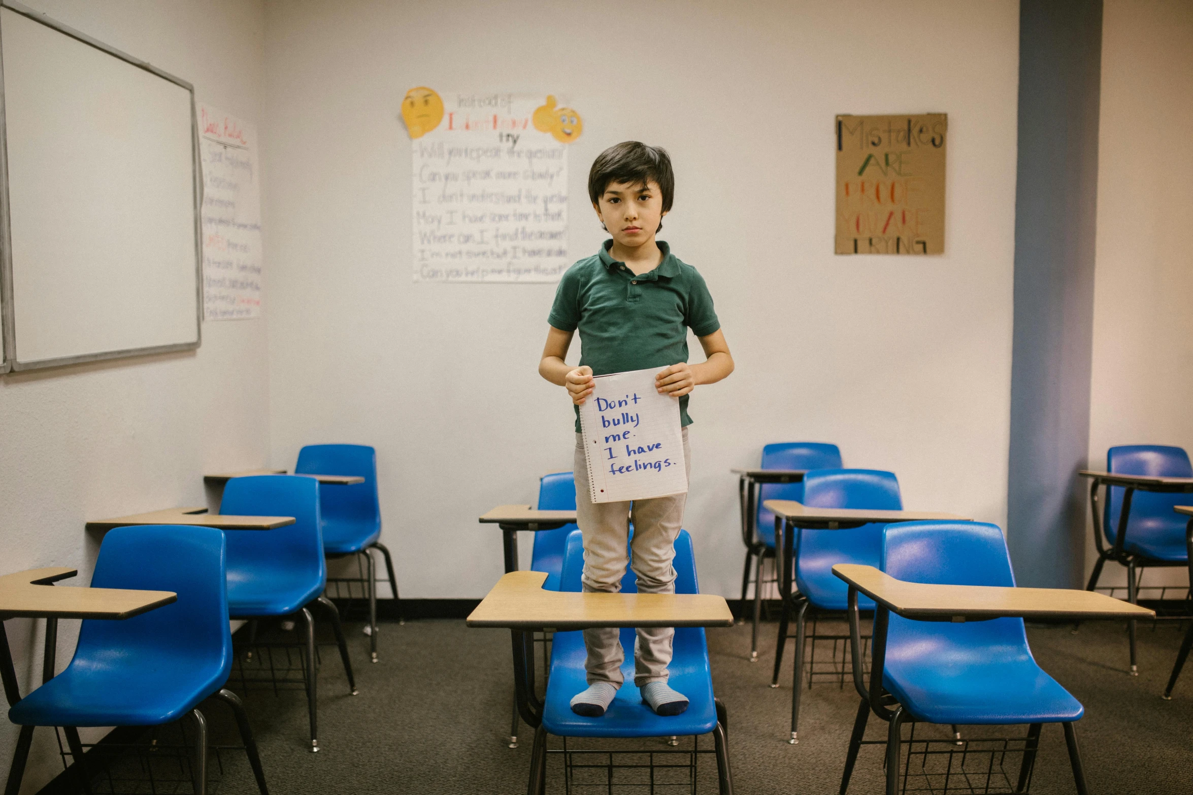 a young boy holding a sign in a classroom, an album cover, by Carey Morris, pexels contest winner, full body in shot, ethan klein, julia fuentes, 15081959 21121991 01012000 4k