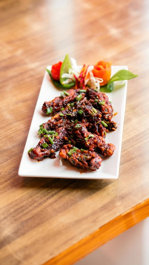 a close up of a plate of food on a table, devi wings, thumbnail, black, meaty