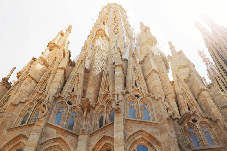 a very tall building with a clock on it's side, by Gaudi, pexels contest winner, tall stone spires, sun light, marilyn church h, front facing
