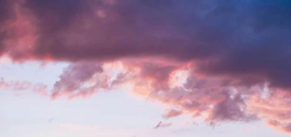 a couple of cows standing on top of a lush green field, an album cover, by Sophie Pemberton, unsplash, aestheticism, dramatic pink clouds, purple sunset, cloud in the shape of a dragon, abstract photography