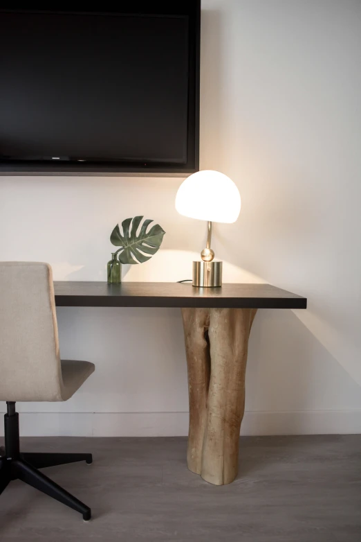 a wooden table topped with a lamp next to a flat screen tv, inspired by Reinier Nooms, unsplash, angle view, wood and gold details, clean soft lighting, 3/4 side view