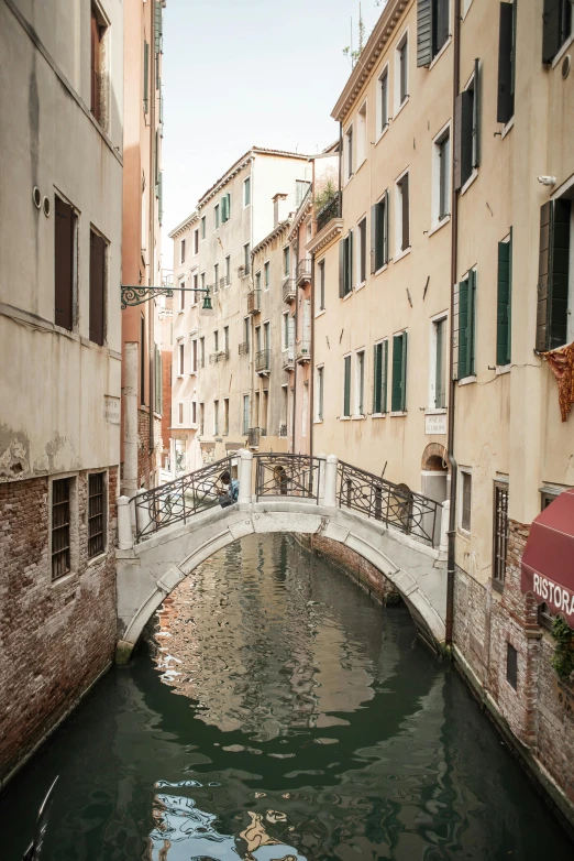 a narrow canal with a bridge over it, by Carlo Martini, trending on unsplash, renaissance, square, sleepy, shady alleys, 2022 photograph