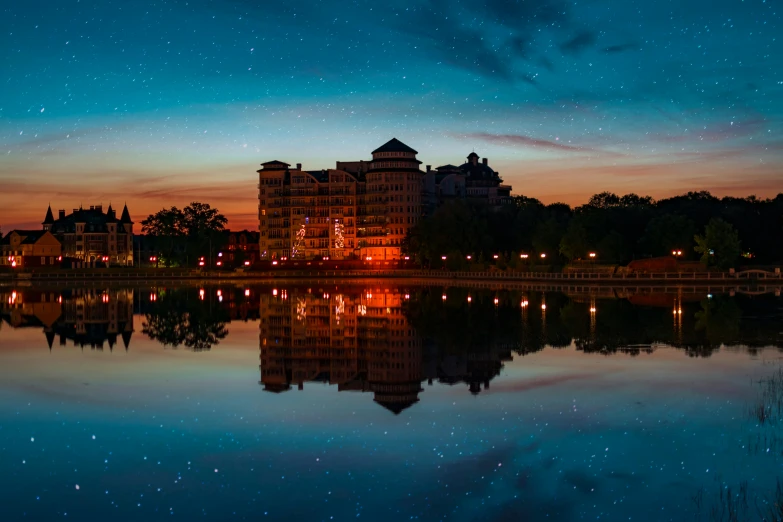 a large body of water with buildings in the background, by Washington Allston, pexels contest winner, magical realism, calm evening, parks and lakes, colorful night sky, from wheaton illinois