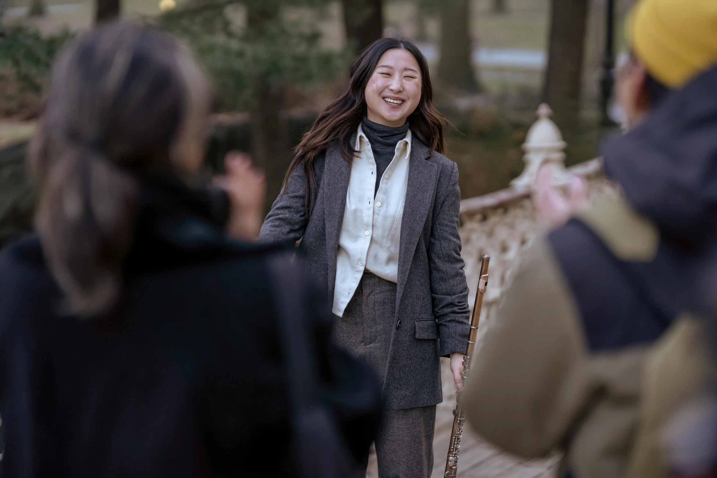 a woman standing on a bridge next to a group of people, inspired by Feng Zhu, on set, enjoying a stroll in the forest, portrait image