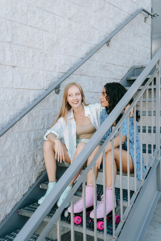 a couple of women sitting on top of a set of stairs, by Carey Morris, trending on pexels, young female, promotional image, happy friend, lower quality