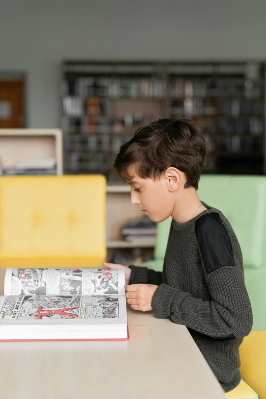 a boy sitting at a table reading a book, a cartoon, pexels contest winner, comic book hero, architect, ignant, high quality photo