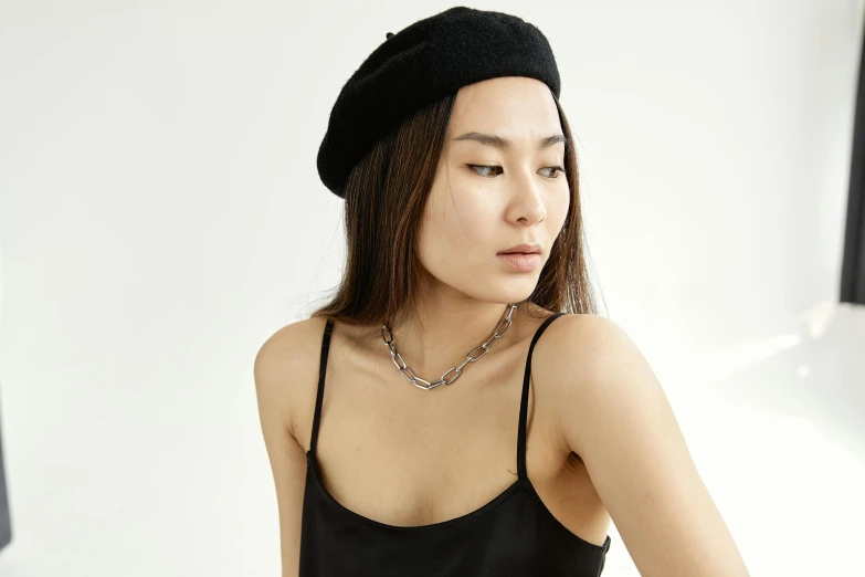 a woman in a black top and a black hat, trending on pexels, rococo, wearing a beret, wearing a chain, asian female, full product shot