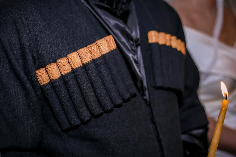 a close up of a person holding a candle, an album cover, inspired by Agustín Fernández, tactical vests and holsters, cigars, in a row, black and terracotta