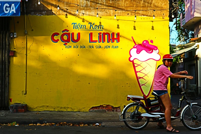 a man that is standing next to a bike, by Sun Long, ice cream on the side, in style of lam manh, fluorescent, pink and yellow