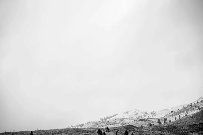 a group of people riding horses down a dirt road, a black and white photo, minimalism, mountain snow, idaho, abstract nature landscape, on the top of a hill