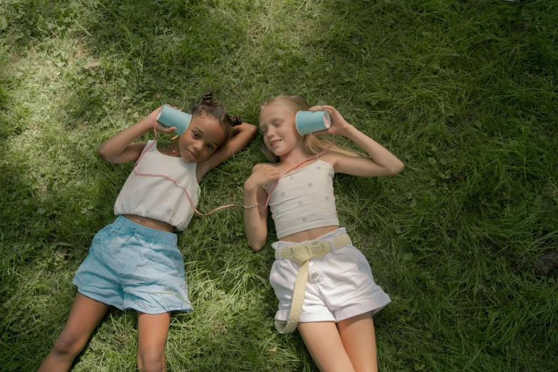 a couple of girls laying on top of a lush green field, by Lee Gatch, pexels contest winner, milk, blue slide park, sydney sweeney, avatar image