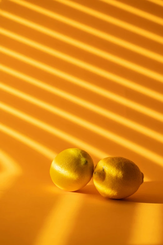 two apples sitting next to each other on a table, unsplash contest winner, light and space, yellow aura, shadow play, 🐿🍸🍋, curved lines