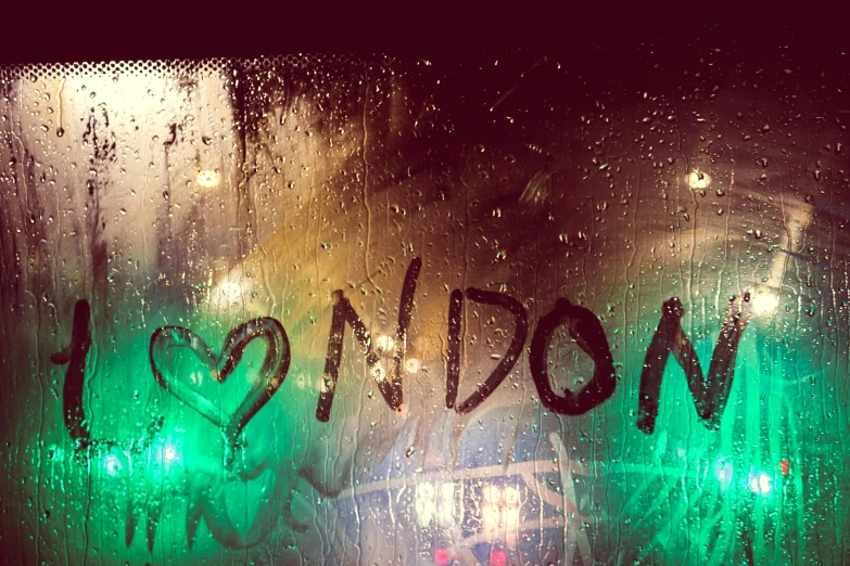 a window with the word london written on it, an album cover, inspired by Nan Goldin, trending on pexels, graffiti, fading rainbow light, green rain, the feeling of boredom, andro