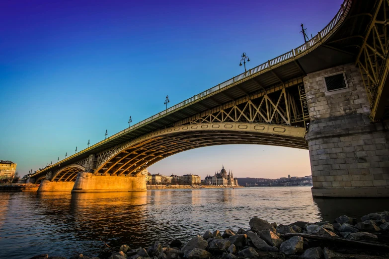 a bridge over a river with a building in the background, by Tom Wänerstrand, pexels contest winner, budapest, taken at golden hour, panoramic, slide show