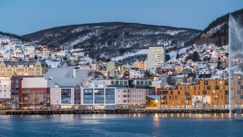 a large body of water next to a city, inspired by Edwin Georgi, pexels contest winner, snowy fjord, evening light, festivals, panoramic