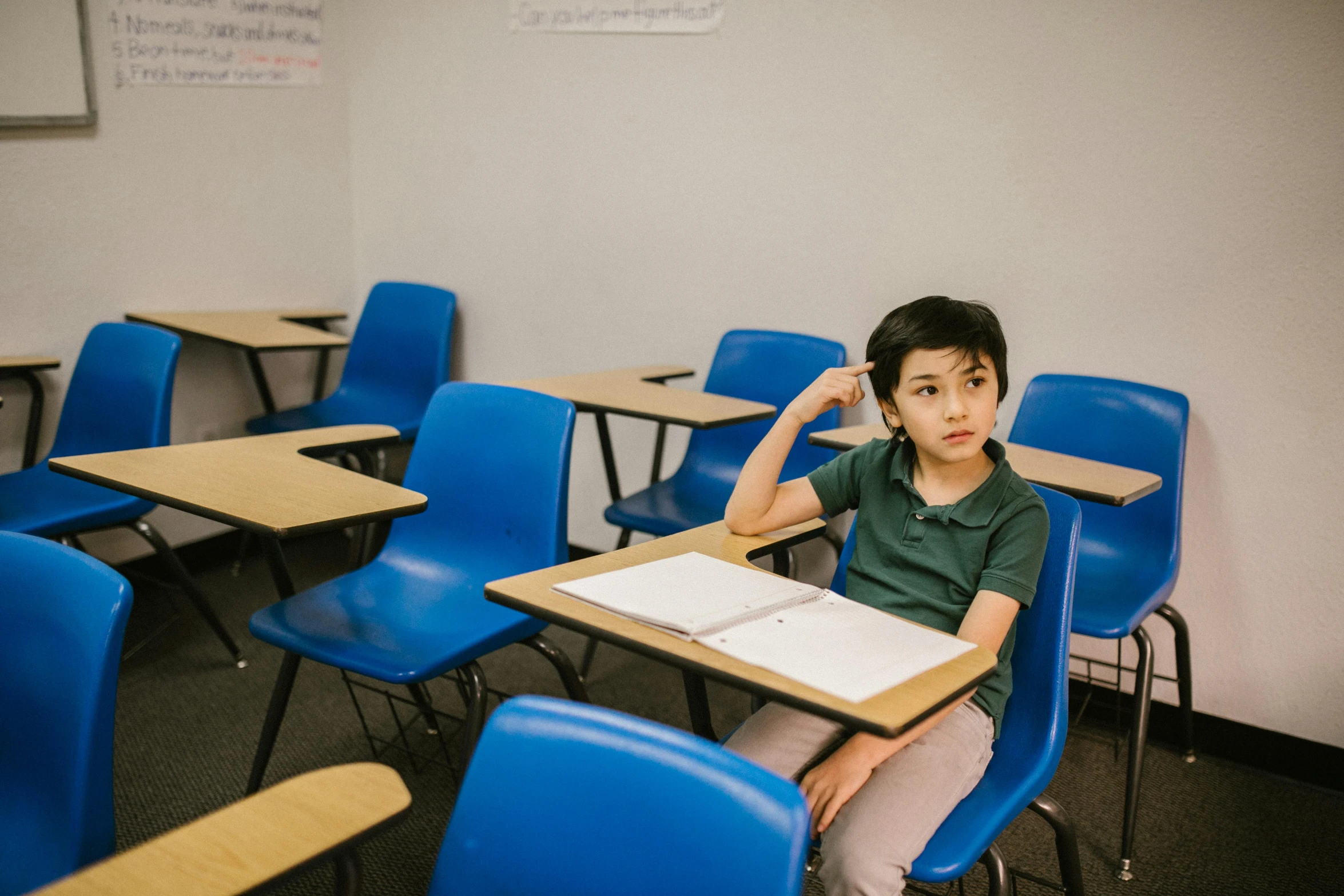 a young boy sitting at a desk in a classroom, pexels contest winner, fan favorite, plain background, damien tran, confident stance