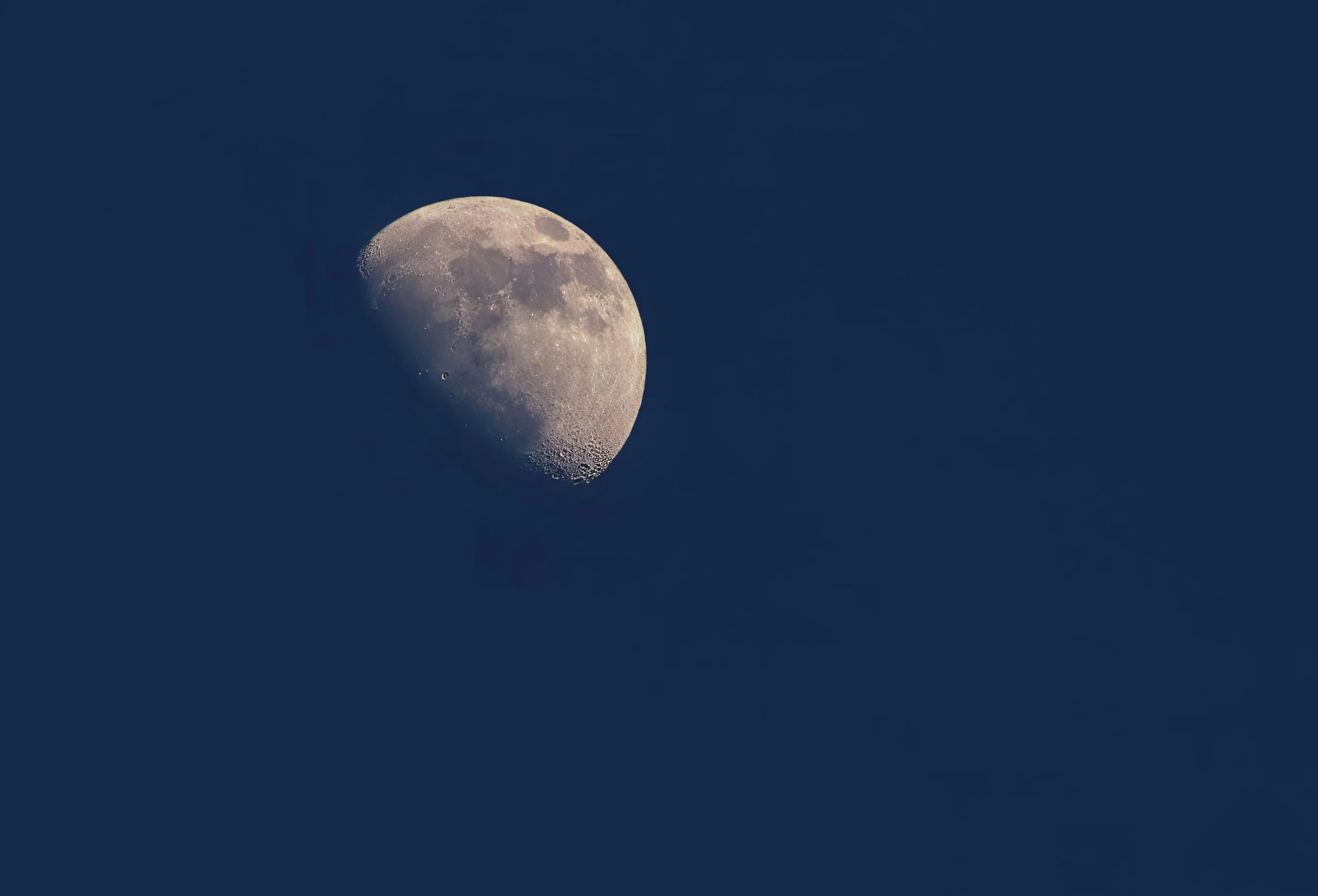 a half moon in a clear blue sky, by Attila Meszlenyi, pexels, on a dark background, grey, post processed, low iso