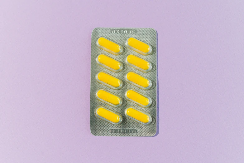 a pill pack sitting on top of a purple surface, by Lubin Baugin, antipodeans, bolts of bright yellow fish, 90s photo, fan favorite, in australia
