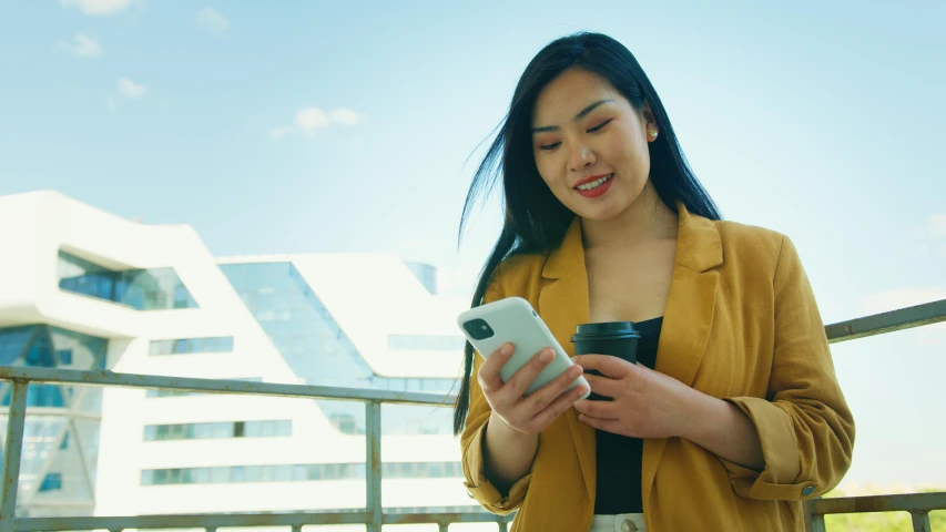 a woman standing on a balcony looking at her cell phone, trending on pexels, asian human, avatar image, professional image, student