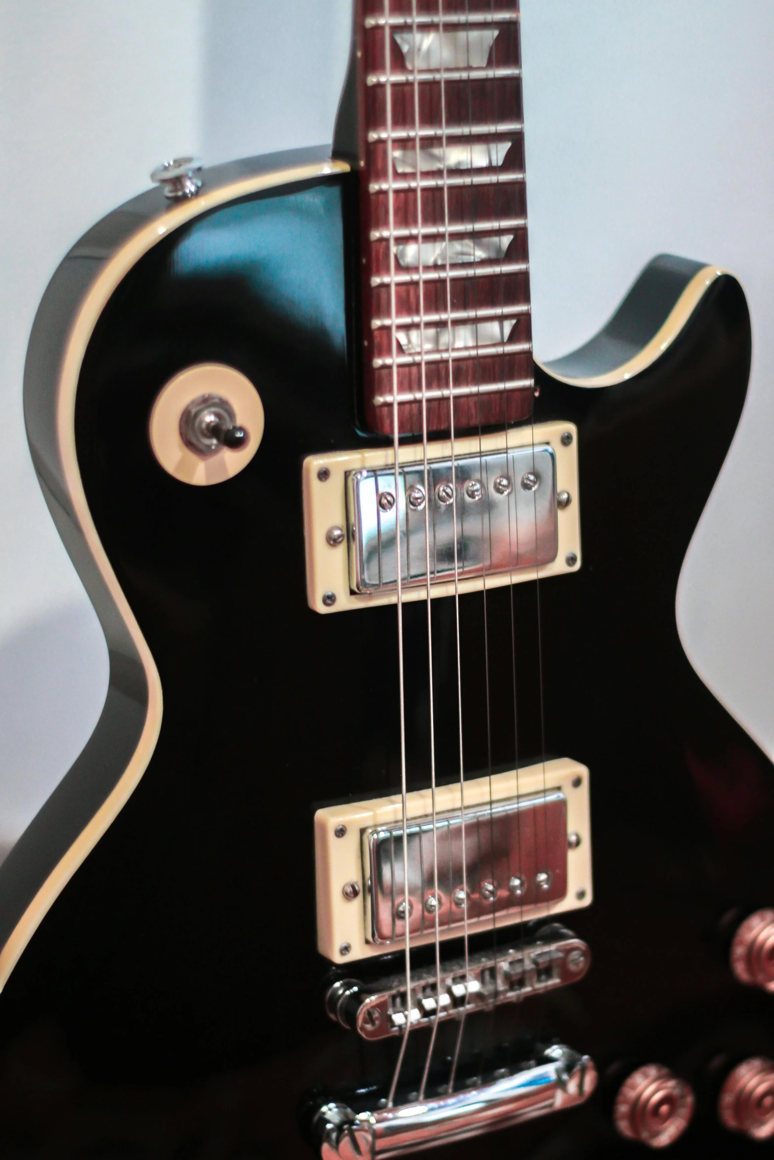 a black electric guitar sitting on top of a table, on display, profile image