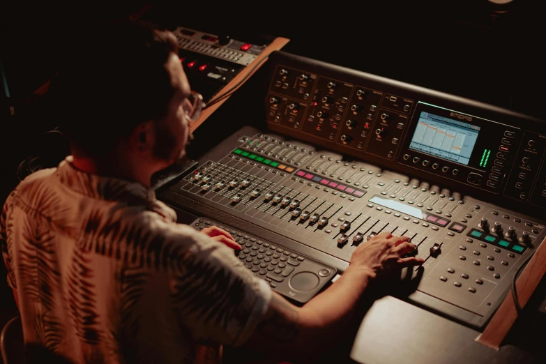 a man sitting in front of a mixing desk, by Dan Luvisi, unsplash, avatar image, theatre equipment, instagram story, full colour