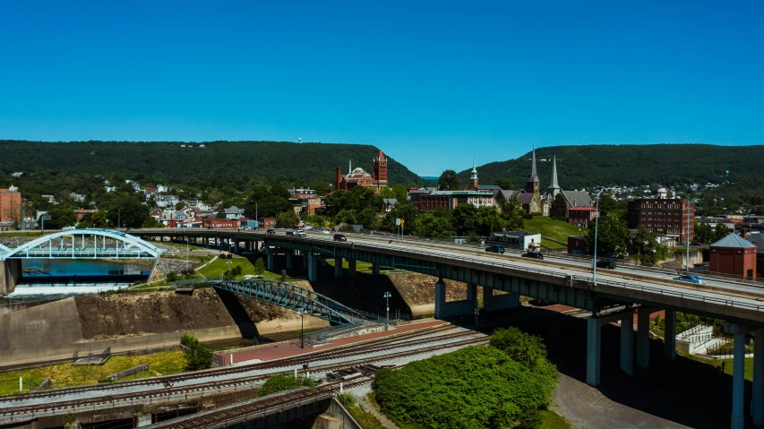 an aerial view of a bridge over a river, by Steve Brodner, pexels contest winner, plein air, town center background, looking over west virginia, panoramic photography, train station in summer