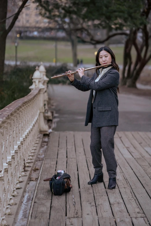 a woman playing a flute on a bridge, an album cover, inspired by Johann Berthelsen, pexels contest winner, shin hanga, central park, 🚿🗝📝, full body in shot, headshot