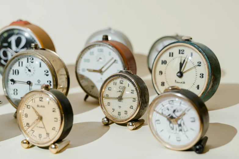 a group of clocks sitting on top of a table, trending on pexels, assemblage, dieter rams, brown, profile pic, full product shot