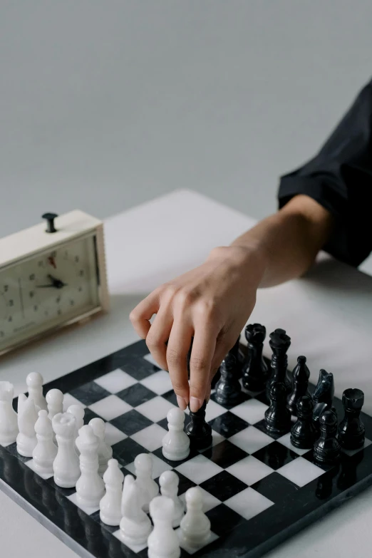 a person playing a game of chess on a table, clock, on a white table, thumbnail, game aesthetic