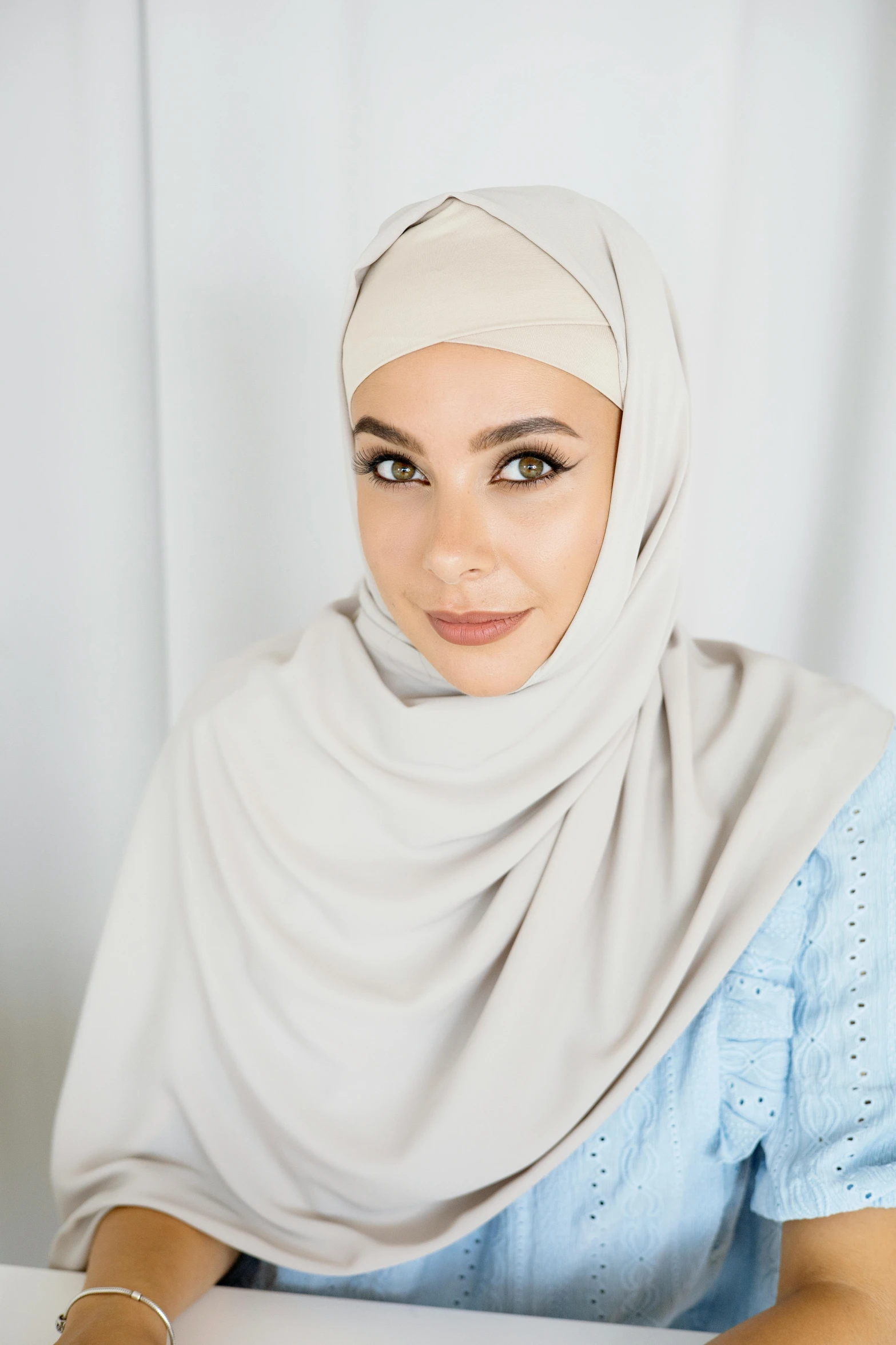 a woman sitting in front of a laptop computer, featured on instagram, hurufiyya, sand color, frontal close up, official product image, covered head