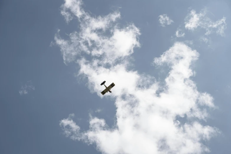 an airplane that is flying in the sky, by Matthias Stom, unsplash, hurufiyya, low quality photo, slide show, biplanes, white clouds