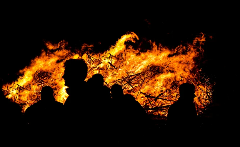 a group of people standing in front of a fire, an album cover, pexels contest winner, hurufiyya, crowded silhouettes, close-up photo, slash and burn, profile image
