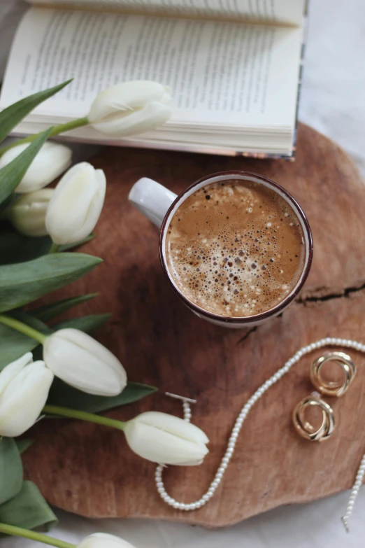 a cup of coffee next to a bunch of white tulips, gold jewelry, curated collection, multiple stories, 10k