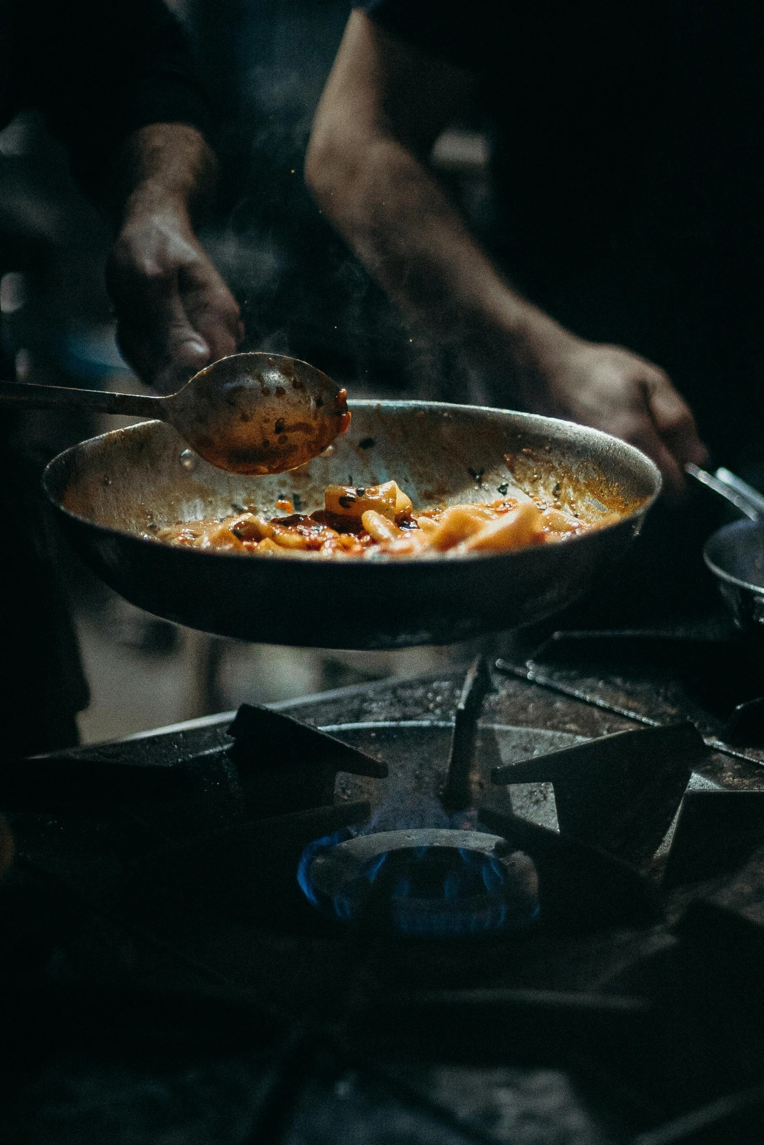 a person cooking food in a frying pan on a stove, by Adam Marczyński, pexels contest winner, renaissance, south east asian with long, square, banner, battered