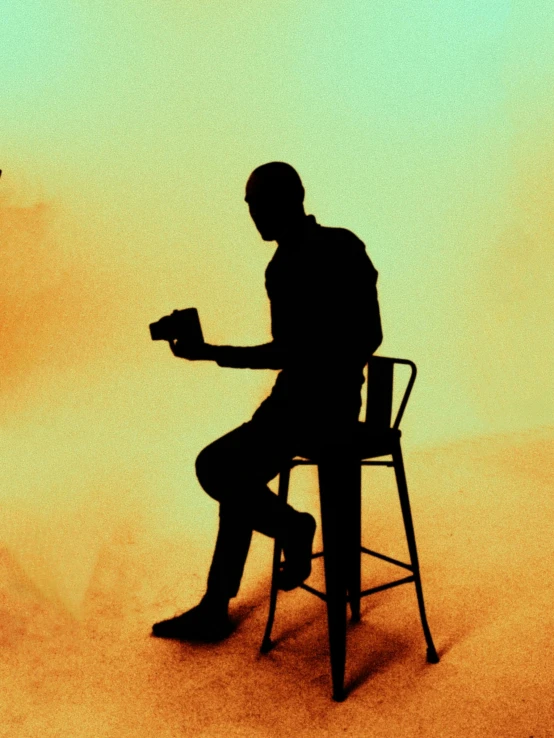 a man sitting in a chair reading a book, an album cover, pexels contest winner, conceptual art, silhouettes, drinking a coffee, ( ( theatrical ) ), standing sideways