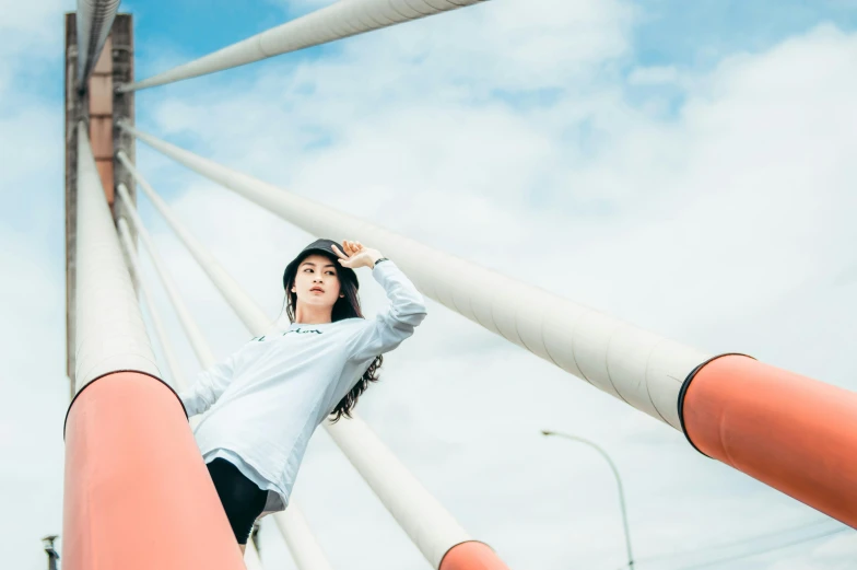 a woman standing on top of a tall orange pole, unsplash, happening, japanese streetwear, bridge, white background, profile image