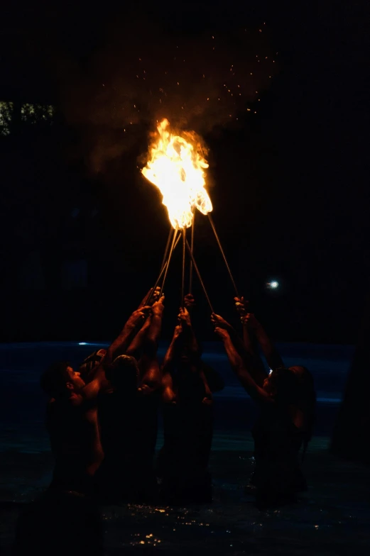 a group of people standing around a fire, during the night, firebreathing, floating lampoons, ceremonial