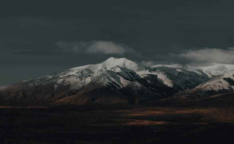 a mountain covered in snow under a cloudy sky, unsplash contest winner, hurufiyya, very dark background, background image, still frame the retro twin peaks, 4 k hd wallpapear