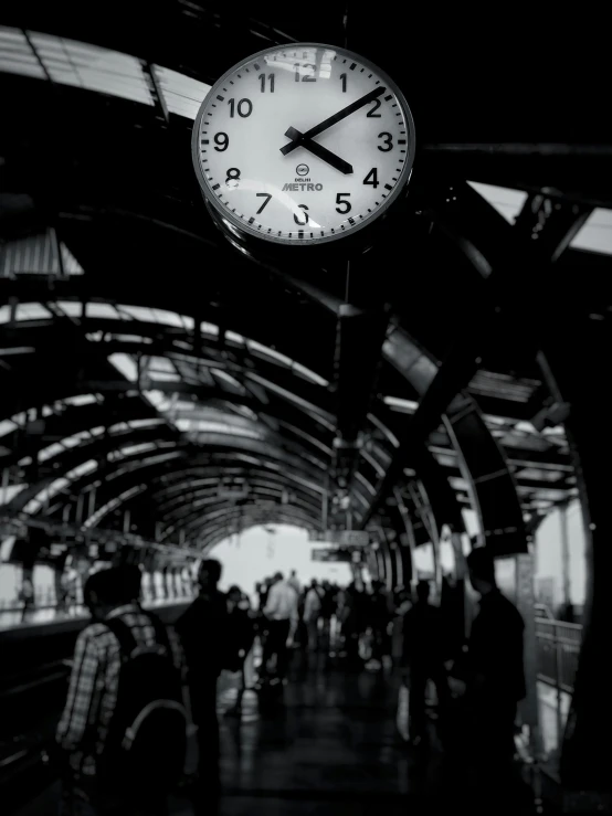 a clock hanging from the ceiling of a train station, a black and white photo, happening, bangkok, \!cinestill 50d! film photo, ilustration, busy with people