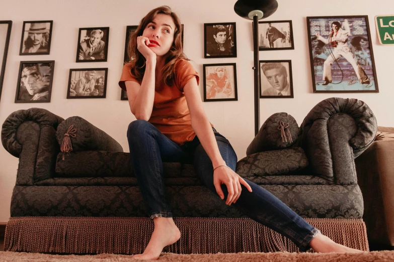 a woman sitting on a couch talking on a cell phone, an album cover, inspired by Nan Goldin, pexels contest winner, photorealism, gorgeous young alison brie, ( ( ( wearing jeans ) ) ), feet posing, portrait sophie mudd